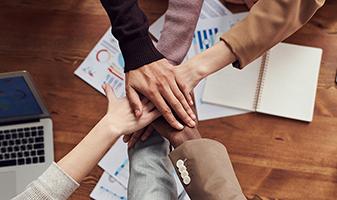 Diverse employee hands together