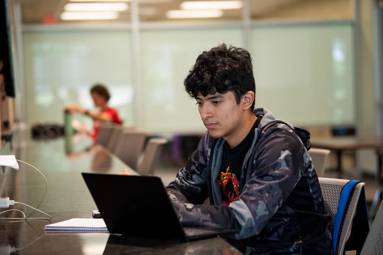 Students collaborating on laptop in student center