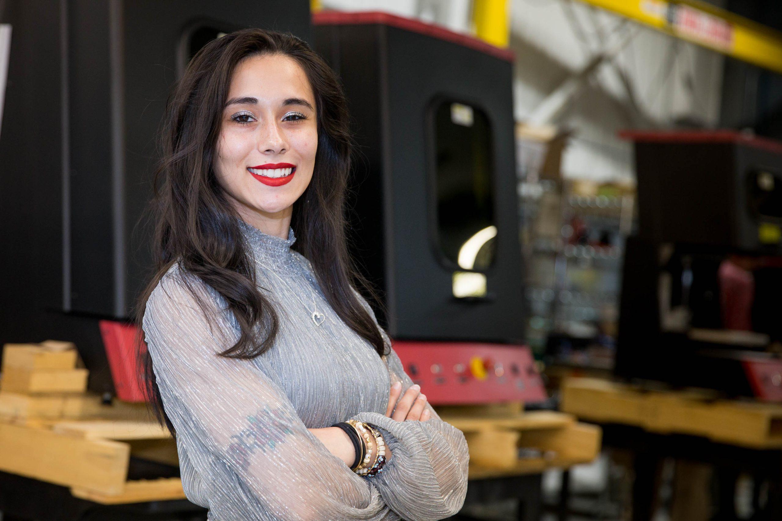 Aleah Abernathy stands in front of mechanical engineering equipment