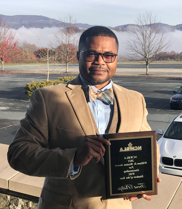 Trent Phillips holds an award