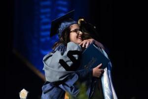 SGA President and Student Commencement Speaker Gabrielle Brown hugs and celebrates with President Spalding as she receives her diploma